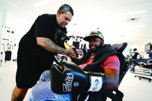 A participant being fitted with a boxing glove as part of an "All Abilities Friday" activity.